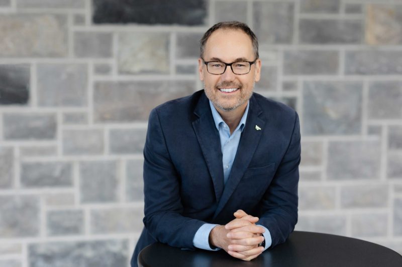 Professional photograph of Bryan Garey in a tailored suit against a stone background